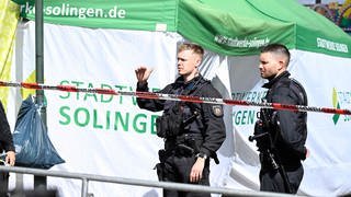 Polizisten hinter Absperrband in Solingen