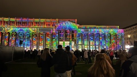 Der Königsbau erleuchtet in unterschiedlichen Farben und Mustern. Die 3D-Laser-Show wird begleitet von Musik.