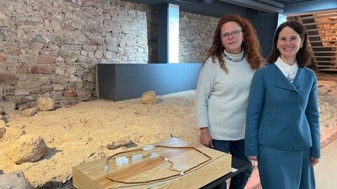 Dr. Bärbel Schulte und Direktorin Dr. Viola Skiba stehen vor den antiken Stadtmauerresten im Keller des Stadtmuseums Simeonstift  