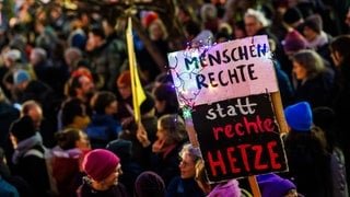 Während einer Demonstration gegen die Migrationspolitik der Union auf dem Platz der Alten Synagoge in Freiburg ist ein Schild mit der Aufschrift "Menschrechte statt rechte Hetze" zu sehen.