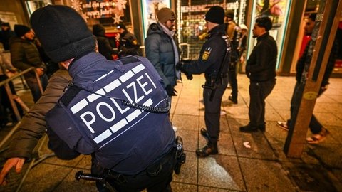 Polizisten kontrollieren am Silvesterabend Menschen am Schlossplatz.