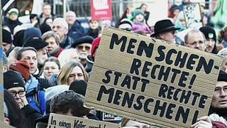 Menschen in Koblenz halten Schilder mit Parolen gegen Rechtsextremismus hoch