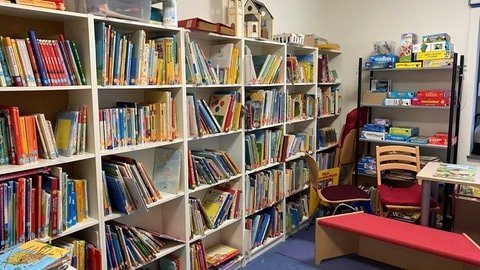 In der Mini-Bücherei der Kita der Evangelischen Auferstehungsgemeinde stehen eine Vielzahl an Büchern in den Regalen. Es gibt auch Sitzbänke zum Vorlesen.