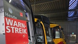 Eine Bahn des KVV hat ein Warnschild mit: "Warnstreik". Beschäftigte im ÖPNV und bei Kitas streiken